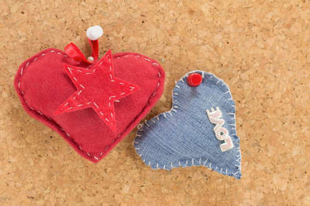 red heart and denim heart hanging against a wooden background