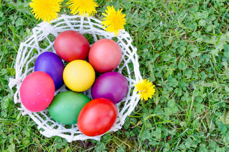 Bowl of home painted Easter eggs on the grassの写真素材