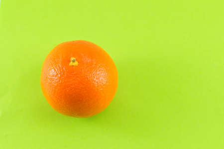 Whole orange on complementary green backgroundの写真素材