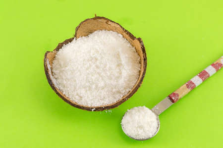 Coconut powder in coconut shell and fresh coconut on green backgroundの写真素材