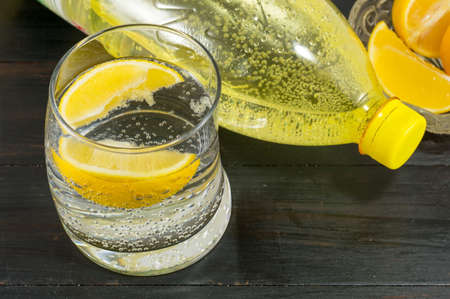 Water with taste of lemon on dark wooden table