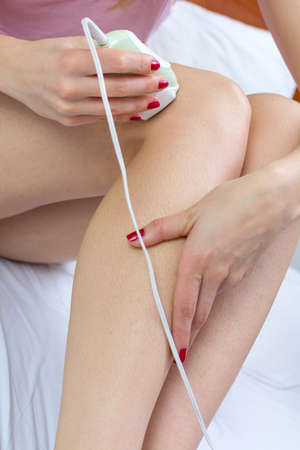 Girl epilates her leg with an epilator at home