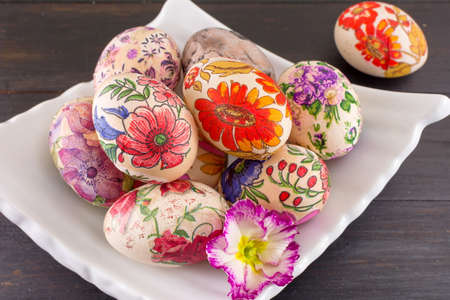 Decoupage decorated Easter eggs on a plateの写真素材