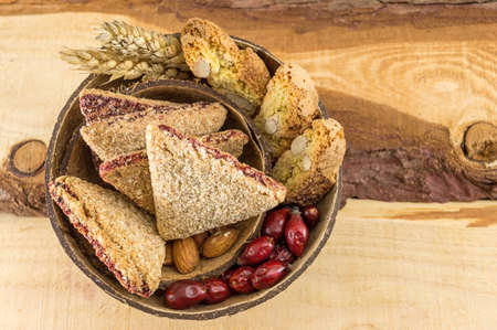 Integral cookies with almonds and rose hips served in a coconut shellの写真素材
