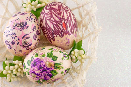 Colorful decoupage decorated Easter eggs in a basketの写真素材