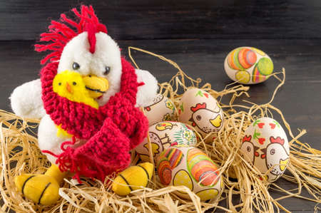 Decoupage decorated Easter eggs and family of toy chickens in a nestの写真素材