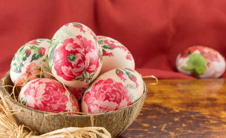 Decorated Easter eggs in a coconut shell as a bowlの写真素材