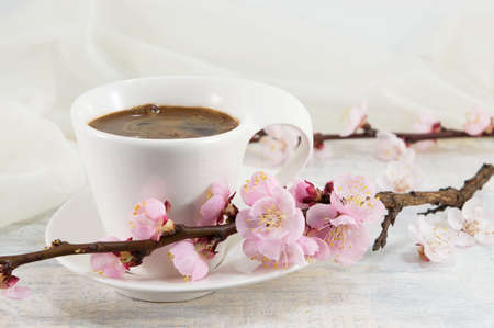 Cup of coffee decorated with cherry blossom flowersの写真素材