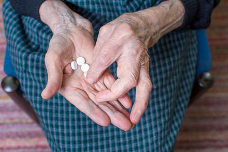 Hands of very old woman taking pillsの写真素材