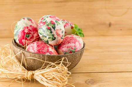 Decorated Easter eggs in a coconut shell as a bowlの写真素材