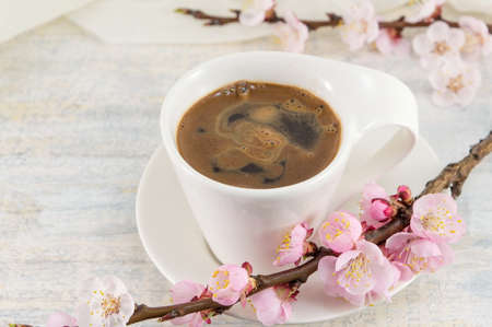 Cup of coffee decorated with cherry blossom flowersの写真素材
