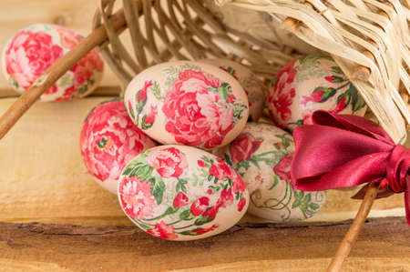 Decorated Easter eggs falling out of vintage wicker basketの写真素材