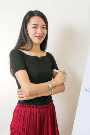 Beautiful asian girl presenting on a flipchart