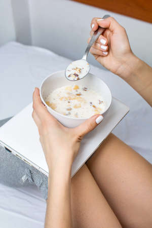 Girl eating cereals for breakfast  in bedの写真素材