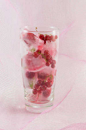 Berry fruit with ice cubes against soft pink backgroundの写真素材