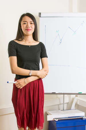 Beautiful asian girl presenting on a flipchartの写真素材