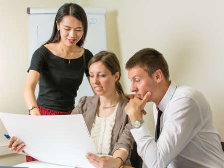 Multicultural team of designers looking at a project at work