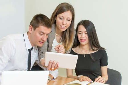 Multicultural team looking at a tablet at the office