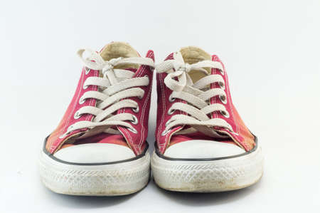 Old and dirty red sneakers on whiteの写真素材
