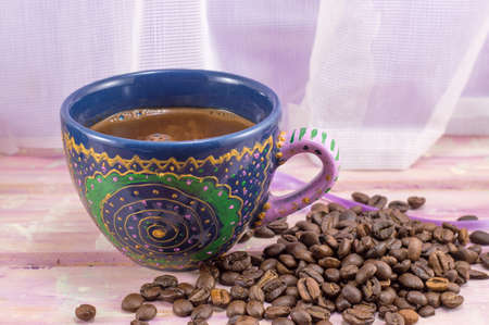 Coffee cup and coffee  beans on a wooden tableの写真素材
