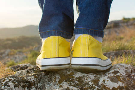 Woman on a hiking trip with close up at yellow sneakers