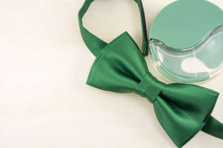 Green Bow tie and parfume  on a wooden tableの写真素材