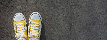 Yellow sneakers decorated with daisies in the parkの写真素材
