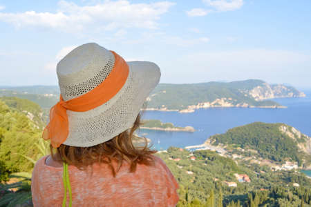 girl with a straw hat posing by the seaの写真素材