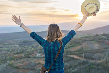 Woman hiker enjoying the sunset with her hand upの写真素材