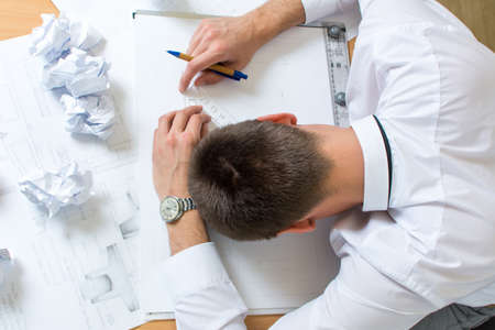 Tired architect sleeping on top of his project
