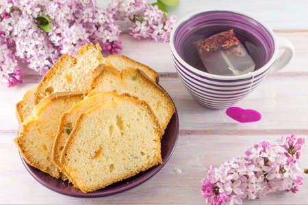 Homemade fruit bread slices with spring flowers and teaの写真素材