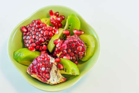 sliced pomegranate and kiwi on a plate