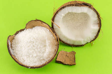 Coconut powder in coconut shell and fresh coconut on green backgroundの写真素材
