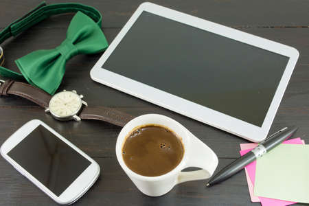 Cup of coffe for a good working day. Coffee and tech accessories on black tableの写真素材