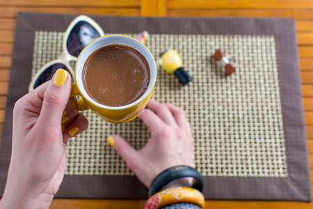Woman having a cup of coffee first personの写真素材