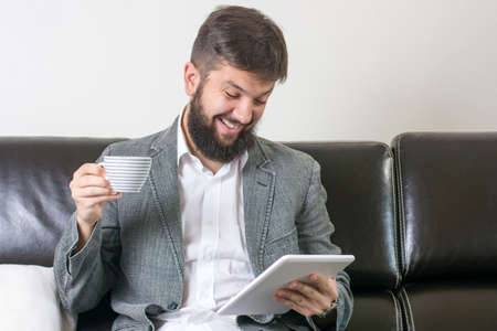 businessman reading news with a cup of coffeeの写真素材