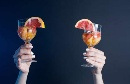 Girls hand holding a cocktail drink at the party