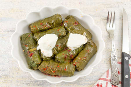 Sarma rolls in a plate covered with spices and sour cream