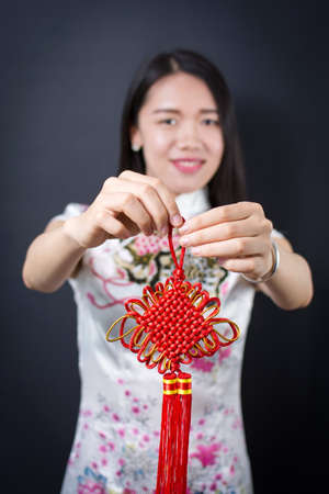 Beautiful asian woman holding a red Chinese knotの写真素材