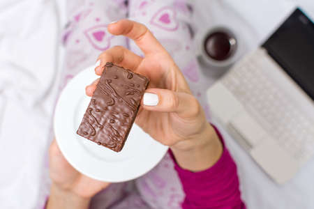 Woman eating biscuit first person viewの写真素材