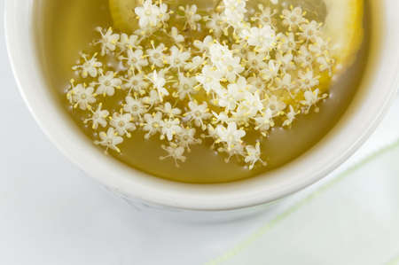 Elderflower tea with lemon served elderflowers top viewの写真素材