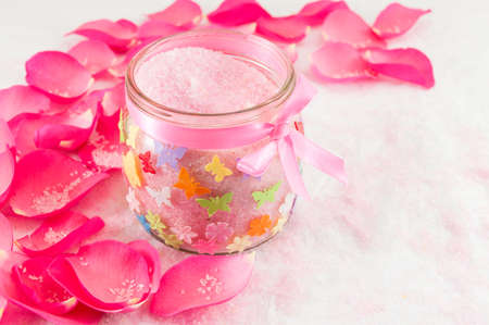 Pink rose on rose petals and bath salt in a jarの写真素材