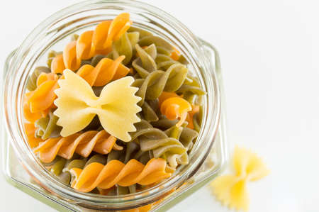 Various pasta in a glass jar on a white backgroundの写真素材