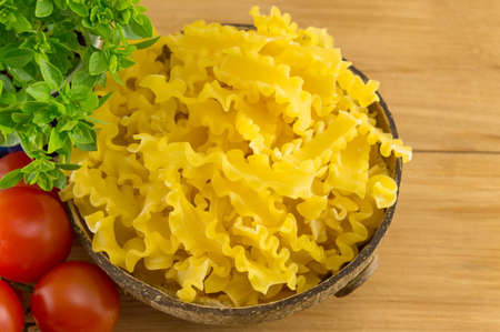 Bow tie farfalle pasta in a bowl with vegetables on the tableの写真素材