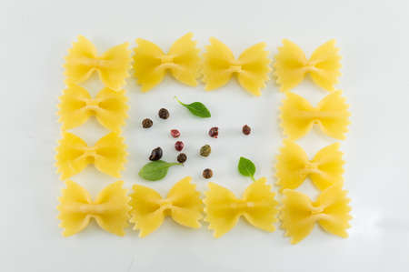 Farfalle pasta forming shapes on white backgroundの写真素材