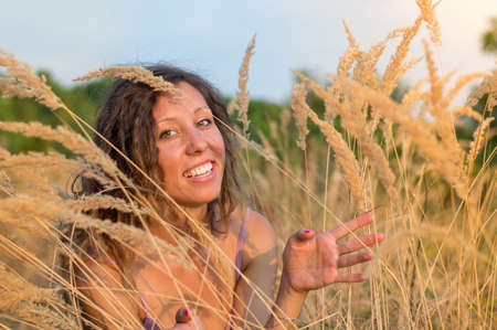 Young beautiful woman in a field of wheatの写真素材