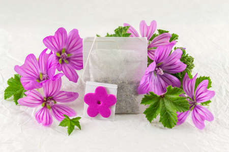 Malva sylvestris, mallow teabag and flowers bouquet on white fabricの写真素材