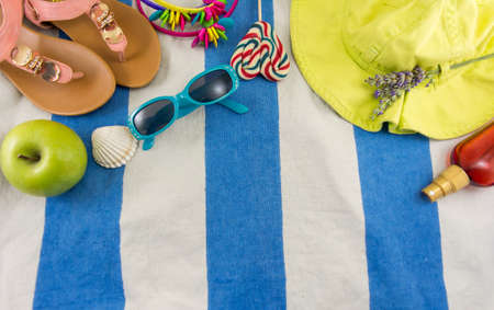 Summer accessories on beach towel top view