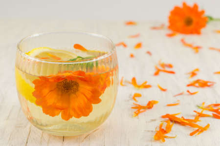 marigold flower herbal tea with lemon slices in a glassの写真素材