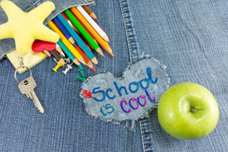School is cool sign with creative learning objects on blue jeansの写真素材